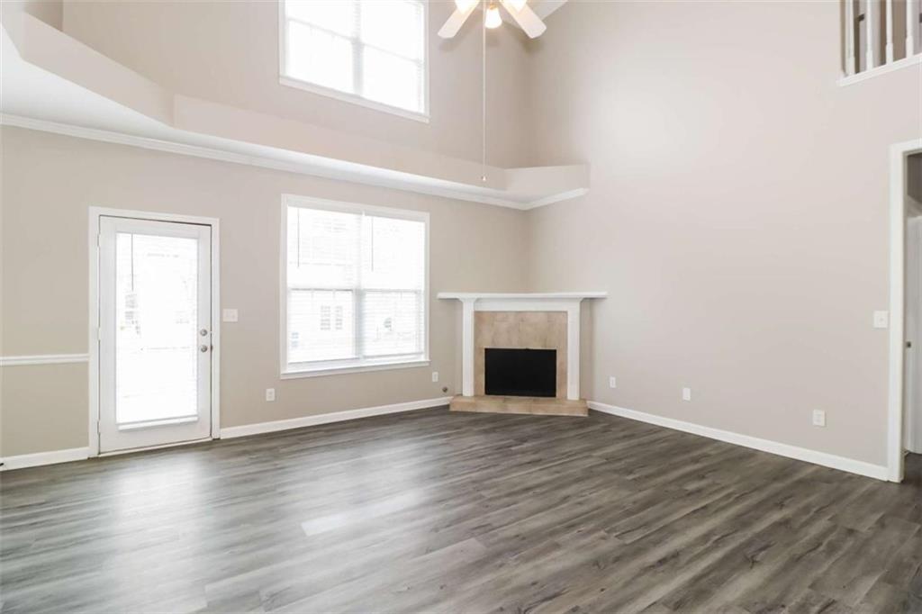 2312 Temple View Drive Snellville, GA 30078 - Photo 7 of 15 an empty room with wooden floor fireplace and windows