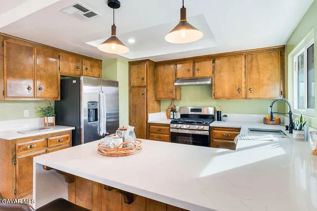 a kitchen with a refrigerator a stove a sink dishwasher with a dining table and chairs