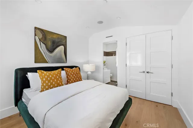 a bedroom with a bed and a painting on the wall