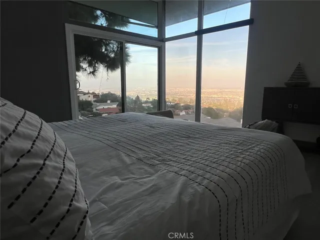 a large bed sitting in a bedroom next to a window