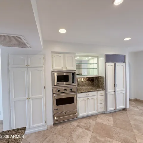 a view of a hallway with wooden floor and a room