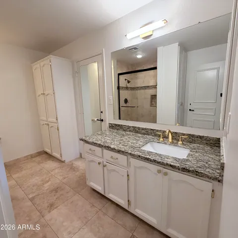 a view of an empty room with wooden floor and window