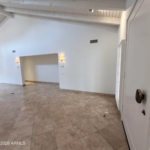 an empty room with windows and chandelier