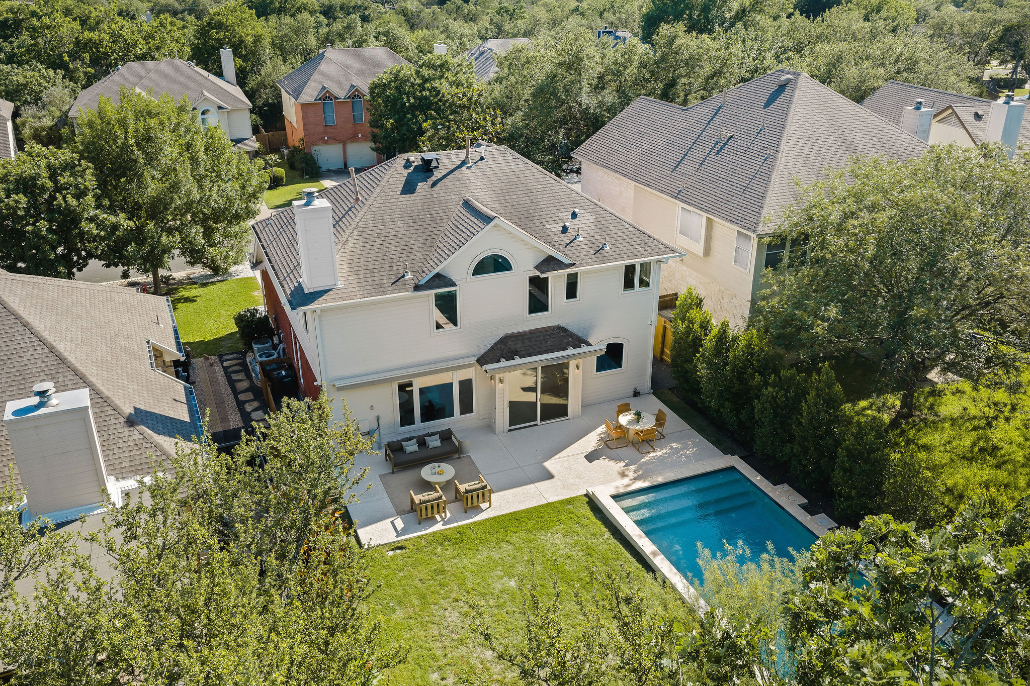 6500 Clay Allison Pass Austin, TX 78749 - Photo 39 of 39 Rear exterior featuring a rectangular pool with integrated steps, a paver patio, and a sliding glass door