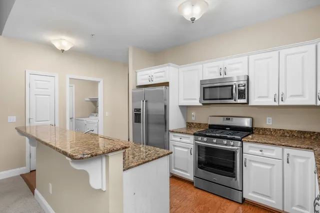 a kitchen with granite countertop a sink stove and refrigerator