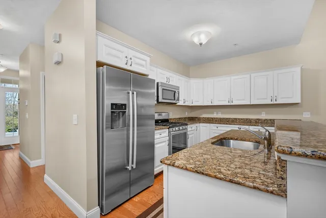 a kitchen with a refrigerator sink and cabinets