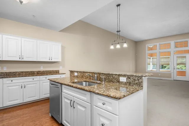 a kitchen with granite countertop a sink and cabinets