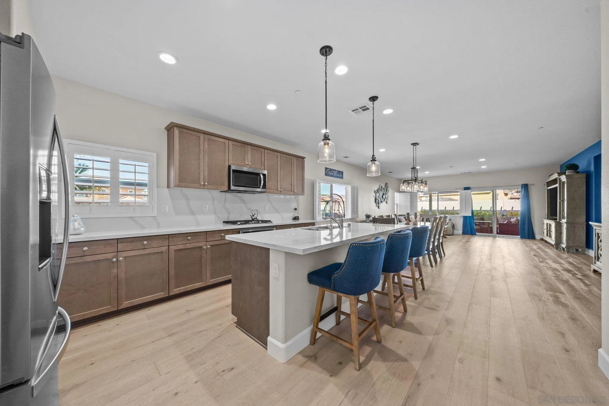 35778 Esperia Way Fallbrook, CA 92028 - Photo 20 of 44 a kitchen with stainless steel appliances granite countertop a refrigerator a sink dishwasher a stove and white cabinets with wooden floor