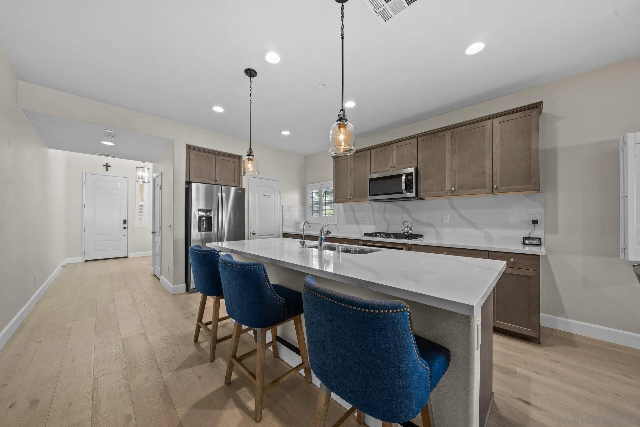 35778 Esperia Way Fallbrook, CA 92028 - Photo 21 of 44 a kitchen with a sink a microwave a refrigerator and chairs