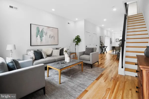 a living room with furniture and wooden floor