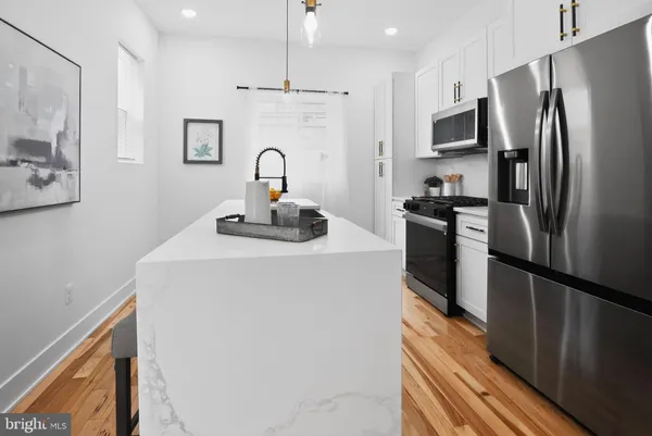 a kitchen with kitchen island a refrigerator sink and stove