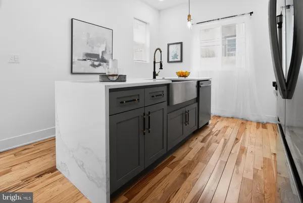 a kitchen with a sink and wooden floor