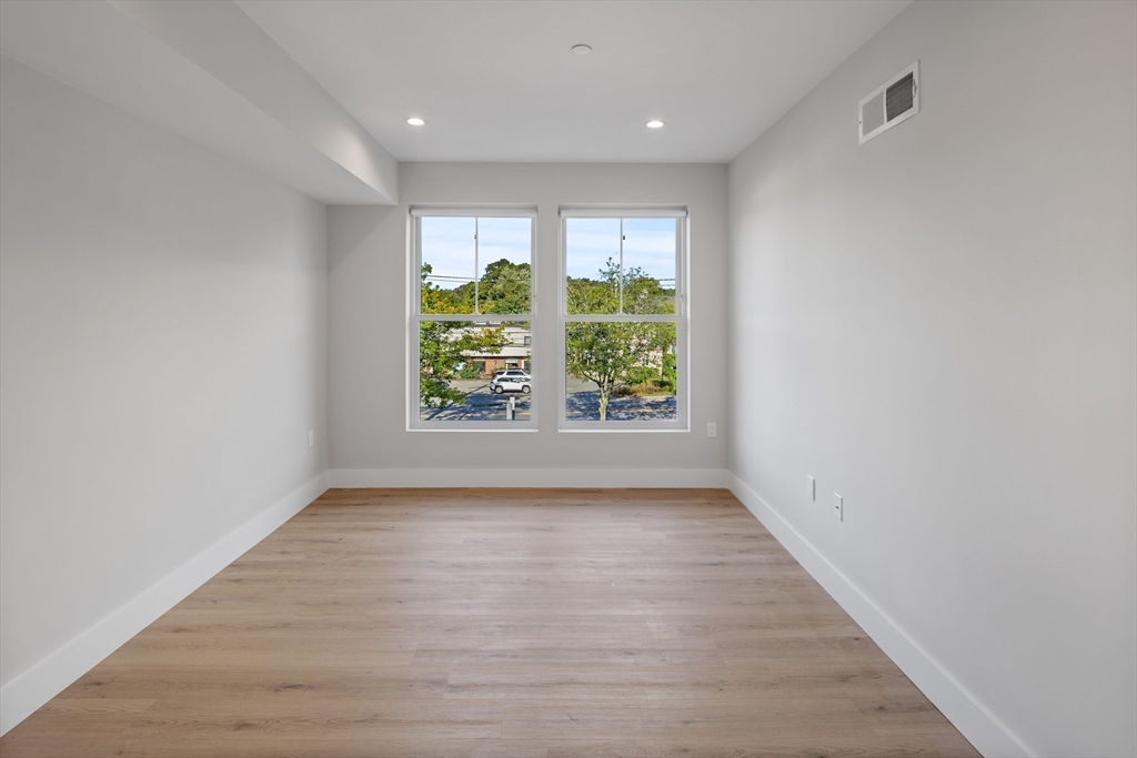 186 Bedford Street, Unit 204 Lexington, MA 02420 - Photo 6 of 10 wooden floor in an empty room with a window