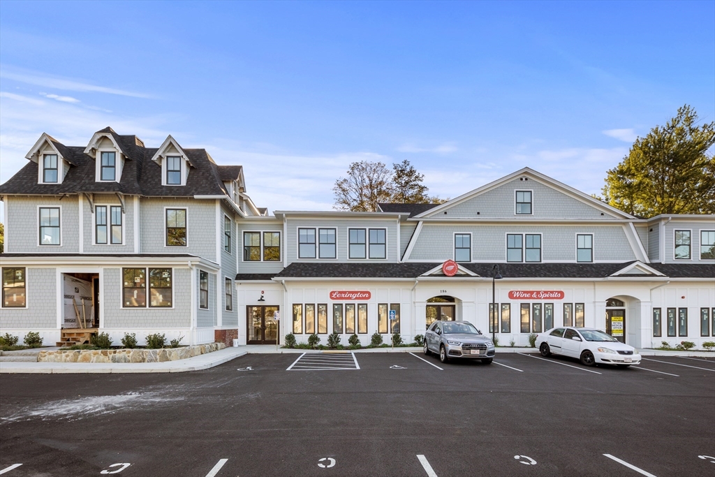 186 Bedford Street, Unit 204 Lexington, MA 02420 - Photo 10 of 10 a front view of a building with lot of cars and trees
