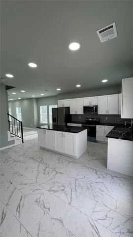 a bathroom with a granite countertop sink a toilet a mirror and shower