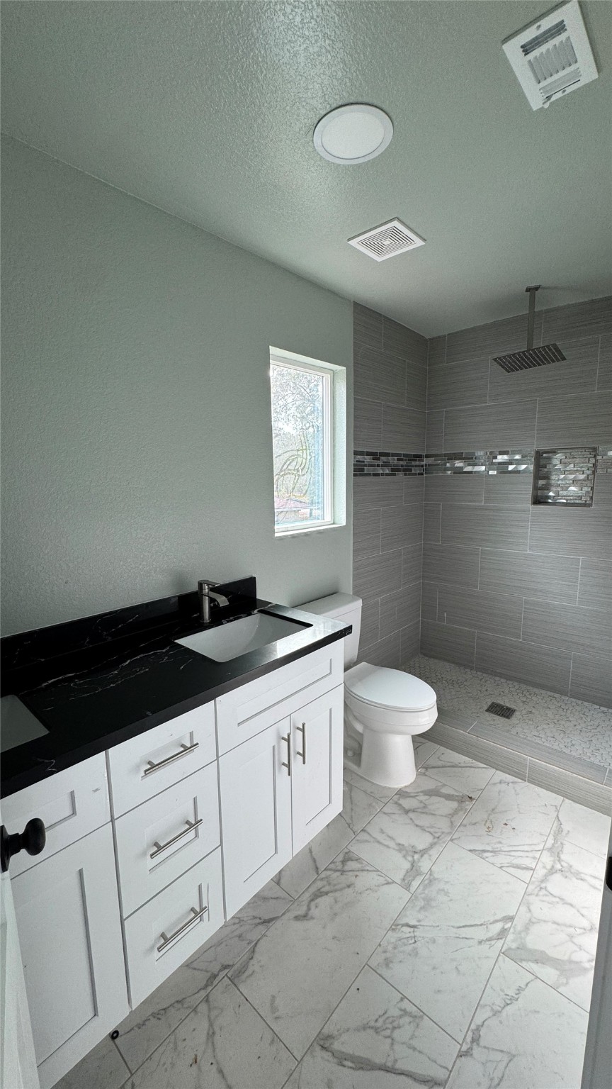 169 South 10th Street Conroe, TX 77301 - Photo 26 of 42 a bathroom with a granite countertop sink a toilet and a shower