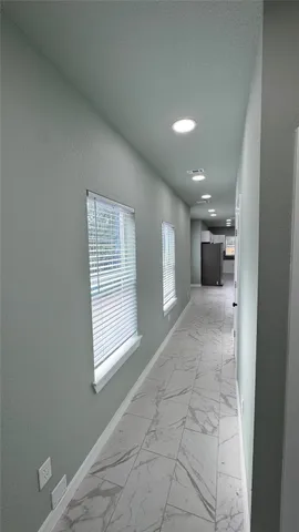 a large white kitchen with kitchen island granite countertop a stove a sink a refrigerator and white cabinets