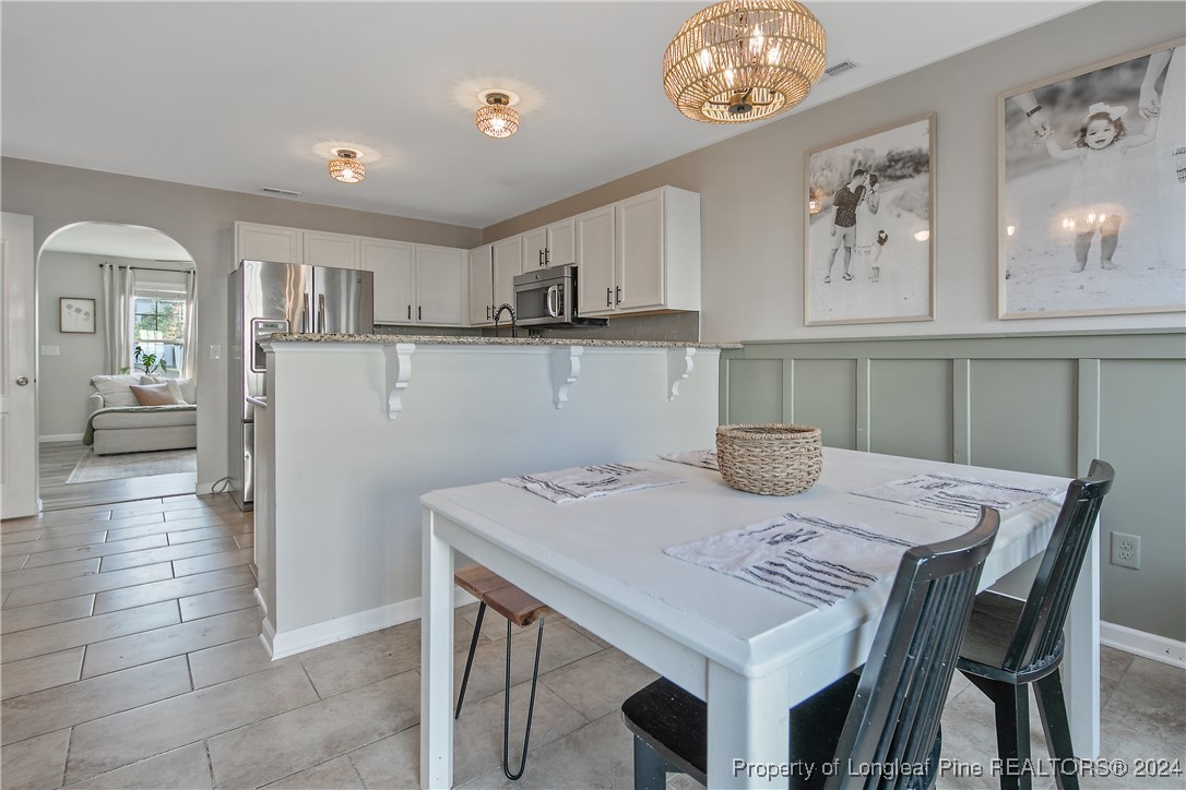 73 Loyalist Road Cameron, NC 28326 - Photo 20 of 42 a kitchen with a table chairs and a refrigerator