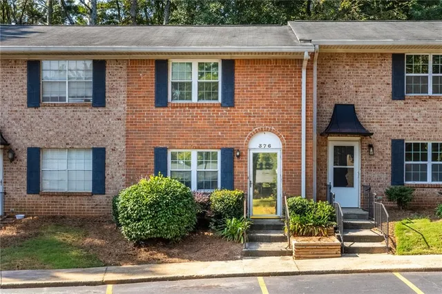 front view of a brick house with a yard