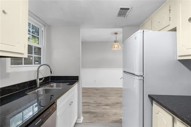 a kitchen with a refrigerator a sink and cabinets