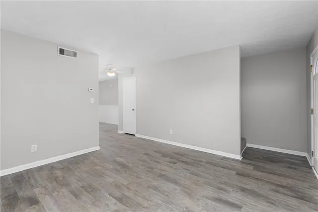 a view of an empty room with wooden floor