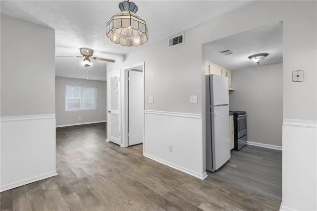 a view of a kitchen with a refrigerator and wooden floor