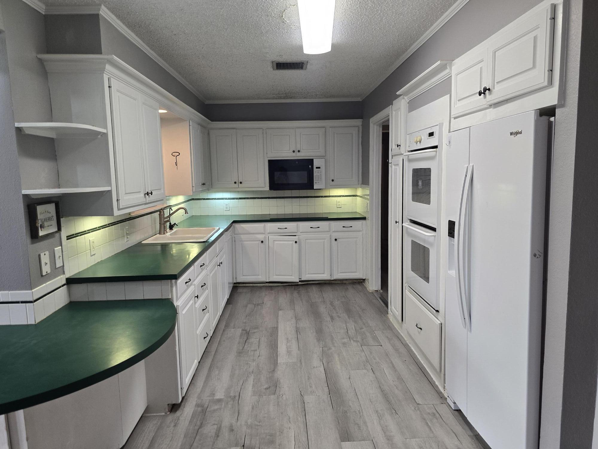 506 North 19th Street Lamesa, TX 79331 - Photo 2 of 29 a kitchen with stainless steel appliances granite countertop a sink and a stove top oven