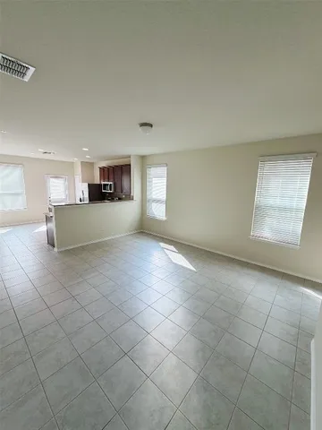a big room with windows and chandelier fan