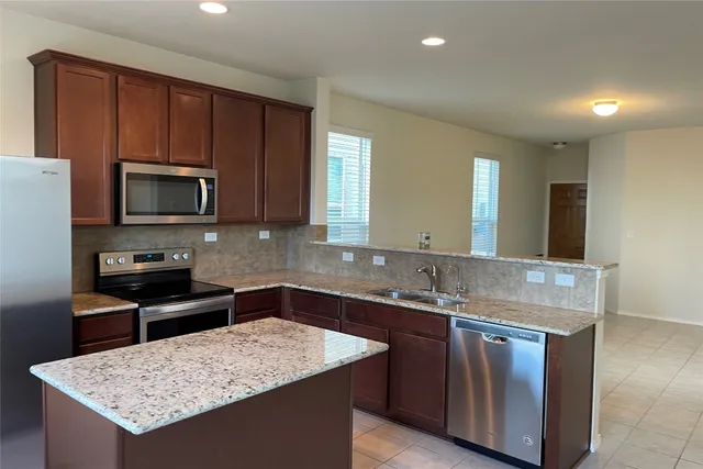 a kitchen with granite countertop wooden cabinets a stove top oven and granite counter tops