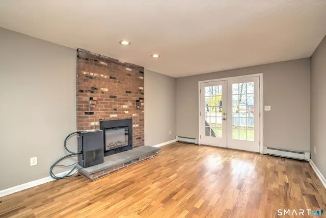 a view of an empty room with a fireplace and a window