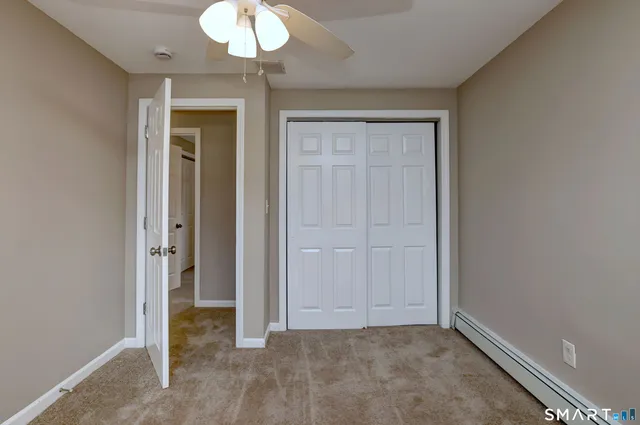 an empty room with a mirror and a chandelier fan
