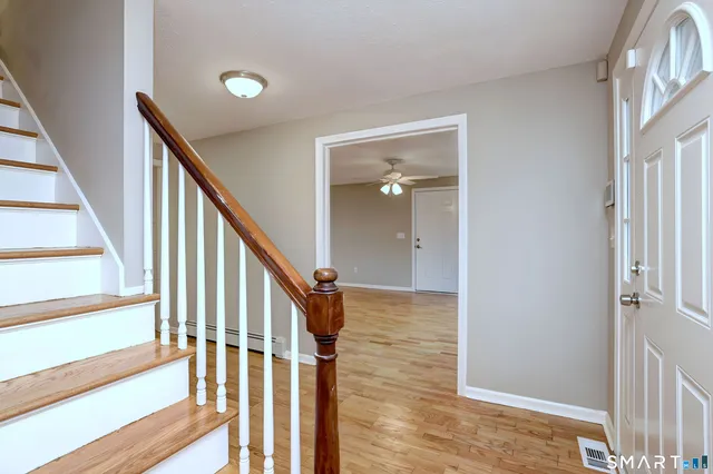 a view of a hallway with wooden floor and staircase