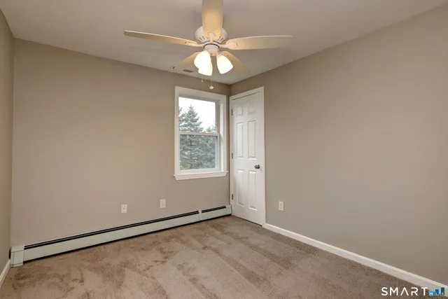 an empty room with a window and a fan