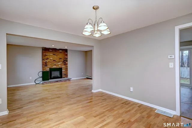 a view of an empty room with a window and fireplace