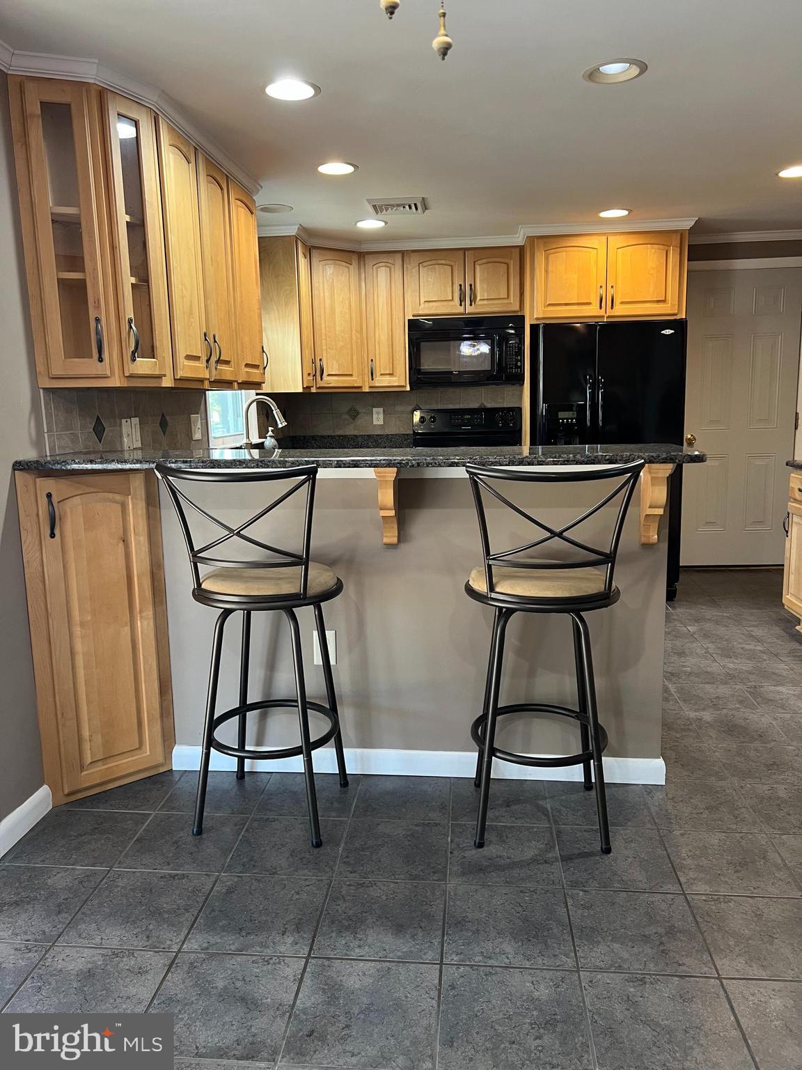 5241 Frances Road Marion Station, MD 21838 - Photo 19 of 146 a kitchen with stainless steel appliances kitchen island granite countertop a stove a sink and a microwave