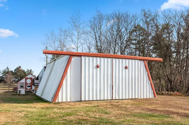 a kitchen with stainless steel appliances granite countertop a refrigerator a sink dishwasher a stove a dining table and chairs with wooden floor