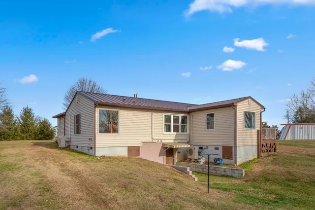 a view of a house with backyard and sitting area