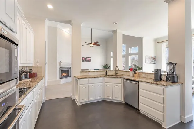 a large kitchen with a large window and stainless steel appliances