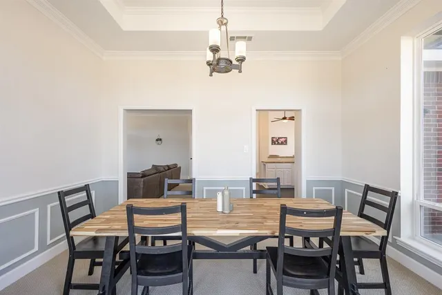 a view of a dining room with furniture and chandelier