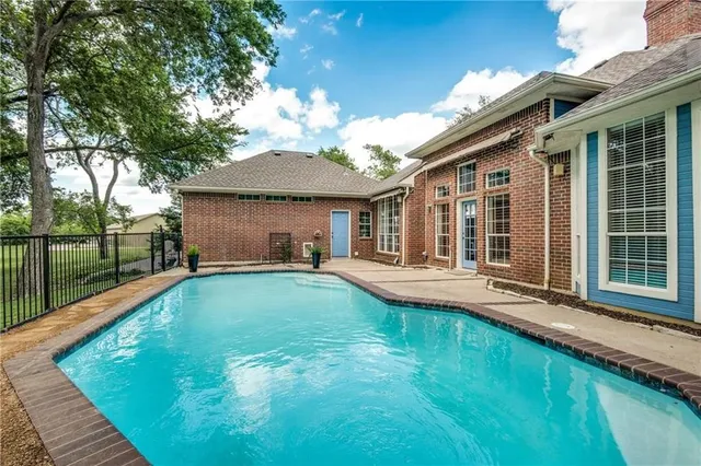 a view of a house with swimming pool and porch with a garden