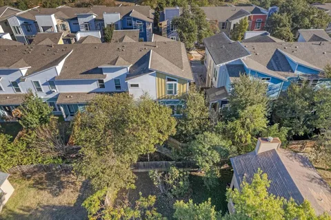 an aerial view of residential houses with outdoor space and trees