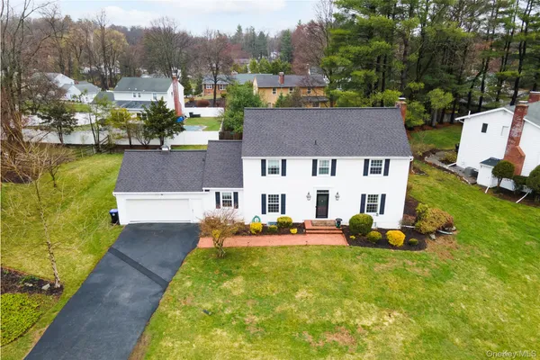 a aerial view of a house with swimming pool garden and trees