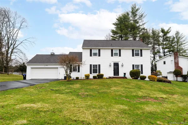 a view of a house with a big yard and large trees