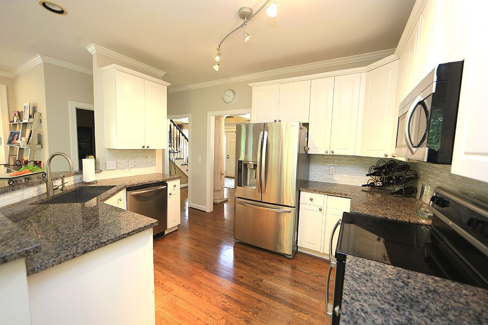 7812 Mayapple Place Raleigh, NC 27613 - Photo 9 of 30 Large sink, SS appliances and granite make this white kitchen an easy place to enjoy. Kitchen
