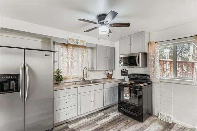 a kitchen with white cabinets and stainless steel appliances
