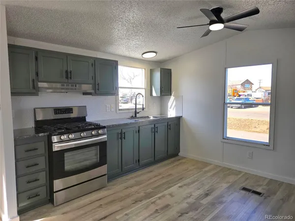 a kitchen with a stove a sink and a window