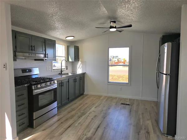 a kitchen with stainless steel appliances granite countertop a stove a refrigerator and a microwave