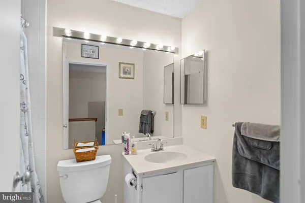 a bedroom with a bed and a lamp on dresser