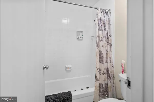 a bathroom with a sink a toilet and shower curtain