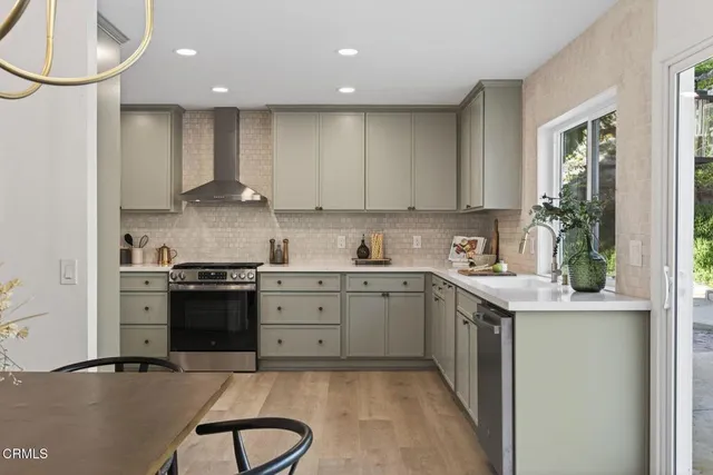 a kitchen with granite countertop white cabinets and stainless steel appliances